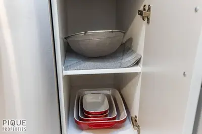 a cupboard with a bowl on a shelf and a bowl on a shelf sidx at *NEW* Modern Suite King Bed! Netflix! Sleeps 4! in Edmonton