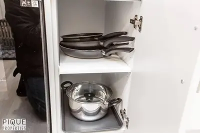 a shelf with pots and pans in a refrigerator at *NEW* Modern Suite King Bed! Netflix! Sleeps 4! in Edmonton