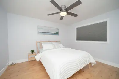 a bedroom with a bed with a ceiling fan at Cozy 3 Bedroom Contemporary Home With Free Parking in Edmonton