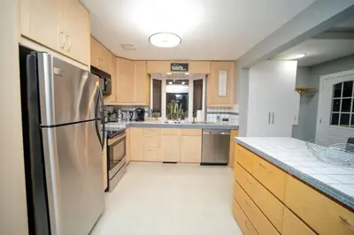 a kitchen with wooden cabinets and a stainless steel refrigerator at Cozy 3 Bedroom Contemporary Home With Free Parking in Edmonton