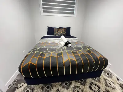 a bed with a stuffed animal sitting on top of it at Gorgeous 6BR New Home for Families in Nisku