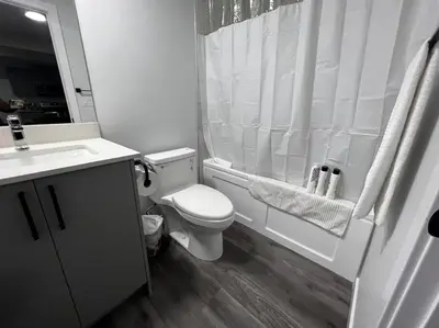 a bathroom with a toilet and a shower and a sink at Gorgeous 6BR New Home for Families in Nisku