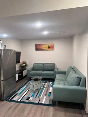 a living room with two green couches and a television at Brand new 1 Bedroom Basement Suite. Wi-Fi,Netflix in Edmonton
