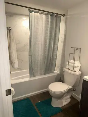 a white bathroom with a toilet and a shower at Brand new 1 Bedroom Basement Suite. Wi-Fi,Netflix in Edmonton