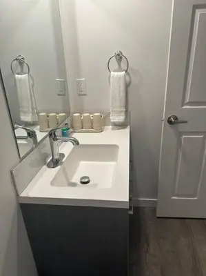 a bathroom with a sink and a mirror at Brand new 1 Bedroom Basement Suite. Wi-Fi,Netflix in Edmonton