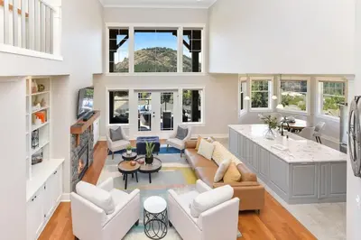 a living room with white furniture and a kitchen at Mount Finlayson View Villa by EMR Vacation Rentals in Victoria