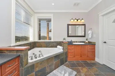 a large bathroom with a tub and a sink at Mount Finlayson View Villa by EMR Vacation Rentals in Victoria