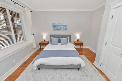 a bedroom with a large bed and two tables at Mount Finlayson View Villa by EMR Vacation Rentals in Victoria