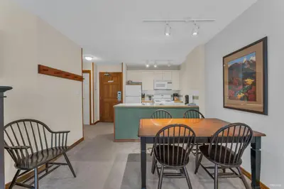a kitchen and dining room with a table and chairs at Best ski in ski out condo #3 in Aspens in Whistler
