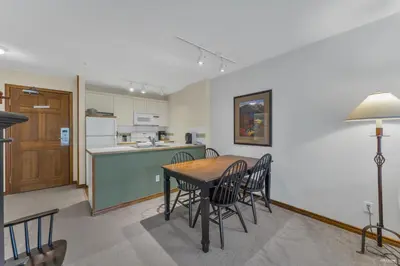 a kitchen and dining room with a table and chairs at Best ski in ski out condo #3 in Aspens in Whistler