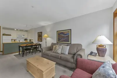 a living room with a couch and a table at Best ski in ski out condo #3 in Aspens in Whistler