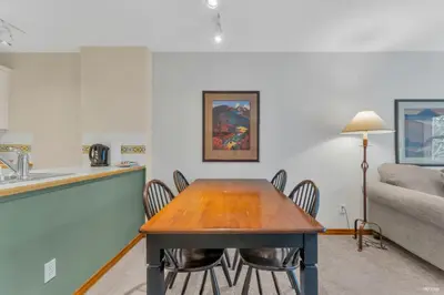 a dining room table with chairs and a couch at Best ski in ski out condo #3 in Aspens in Whistler