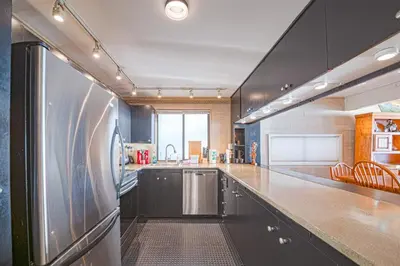 a large kitchen with a stainless steel refrigerator at SALT COTTAGE Waterfront Guest House with Superb Views in West Vancouver