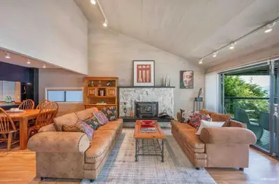 a living room with two couches and a fireplace at SALT COTTAGE Waterfront Guest House with Superb Views in West Vancouver