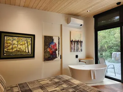 a bathroom with a large tub and paintings on the wall at The Shed at Moon Dance in Madeira Park
