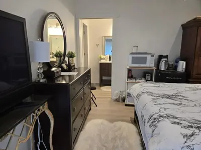 a bedroom with a bed and a dresser with a mirror at Private master bedroom in a farmhouse in Nanoose Bay