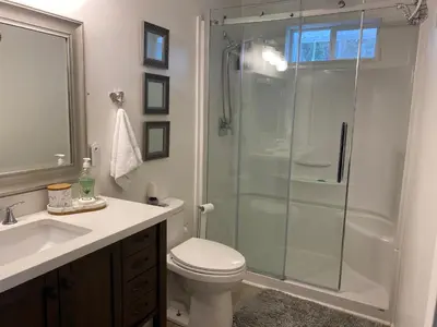 a bathroom with a shower and a toilet and a sink at Private master bedroom in a farmhouse in Nanoose Bay