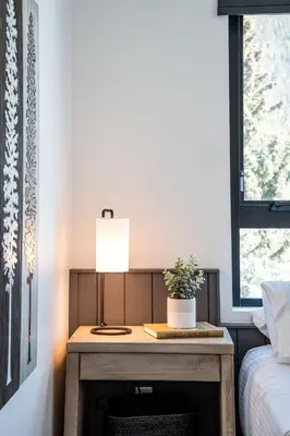 a table with a lamp on it next to a bed at The Big Deck by Revelstoke Vacations in Revelstoke