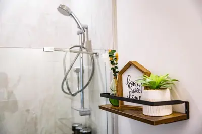 a bathroom with a shower and a shelf with a plant at Monashee Sunshine - Condo with Private Hot Tub in Revelstoke