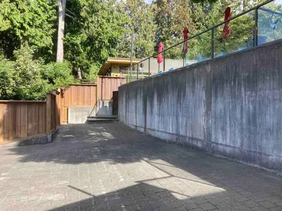 a brick walkway with a fence and a wooden wall at The Lions Self Contained Suite, Shared Pool, Hot Tub, Views in North Vancouver