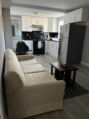 a living room with a couch and a kitchen at Dugg Bed And Breakfast in Victoria