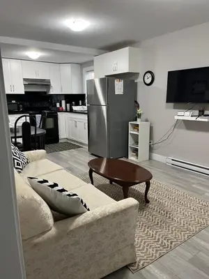 a living room with a couch and a refrigerator at Dugg Bed And Breakfast in Victoria