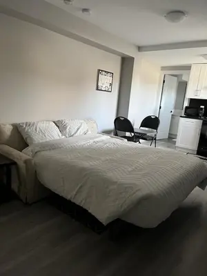 a bedroom with a large bed and two chairs at Dugg Bed And Breakfast in Victoria