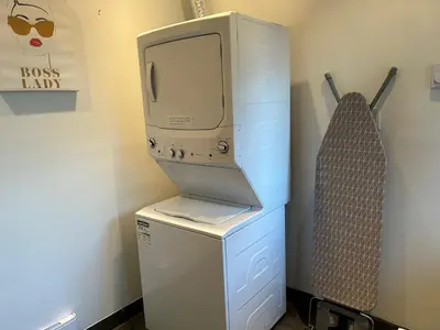 a computer sitting on top of a washer and dryer at Seymour Private Bedroom, Ensuite Bathroom with Shared Pool, Hot Tub with Views in North Vancouver