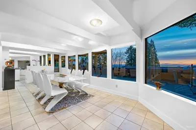 a dining room with a table and chairs and large windows at Seymour Private Bedroom, Ensuite Bathroom with Shared Pool, Hot Tub with Views in North Vancouver
