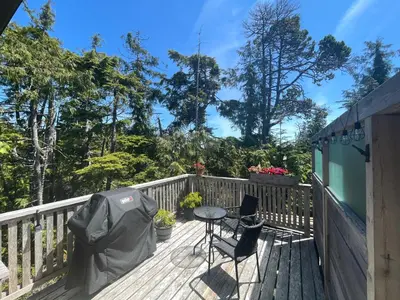 a patio with a table and chairs on a deck at Brown's Beach Guest Suite in Ucluelet