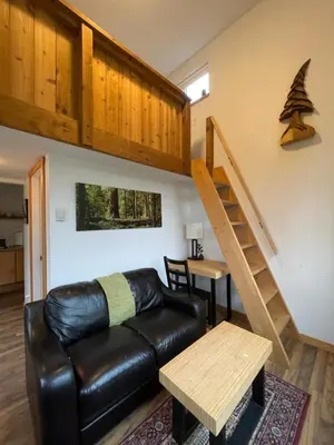 a living room with a couch and a staircase at Brown's Beach Guest Suite in Ucluelet