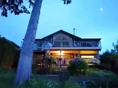 a house with a tree in front of it at Waterfront Eagle Nest in Nanaimo
