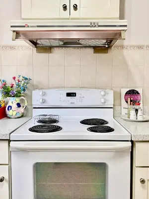 a white stove top oven in a kitchen at Burnaby Metrotown Cozy 3 Bedroom Suite Walk to Skytrain and Malls in Burnaby