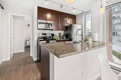 a kitchen with a large counter top in a apartment at GardenView Modern Condo with Parking, Gym, Pool, AC in Vancouver