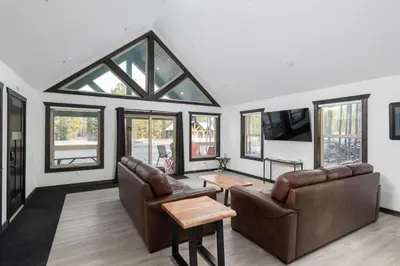 a living room with leather furniture and windows at The Sundance Cabin in Valemount