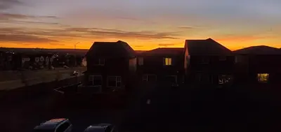 a sunset behind some houses in a city at Delightful 1-bedroom Private Suite in a New Home in Calgary