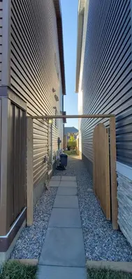 a walk way between two buildings with a fence at Delightful 1-bedroom Private Suite in a New Home in Calgary