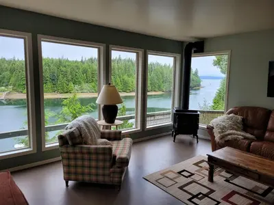 a living room with large windows and a view of the water at Argo's Landing in Bamfield