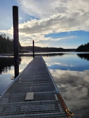 a dock on a body of water with the sky at Argo's Landing in Bamfield