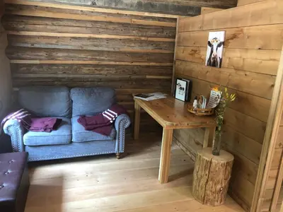 a living room with a blue couch and a table at Mini Moo-light Cabin in Clearwater