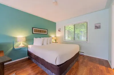 a bedroom with a large bed and a window at The Cabins at Alert Bay in Alert Bay