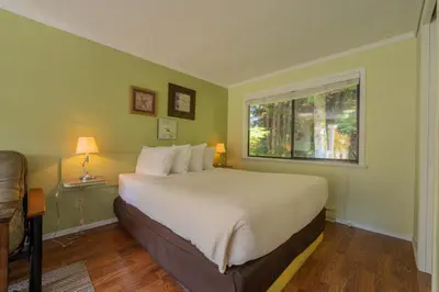 a bedroom with a large bed and a window at The Cabins at Alert Bay in Alert Bay