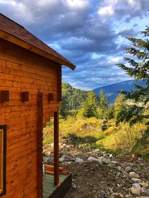 a log cabin with a bench sitting on the porch at Boho Bungalow in Nelson