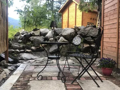 a chair and a lamp on a table in a yard at Boho Bungalow in Nelson
