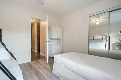 a white bedroom with a bed and a mirror at Polar Peaks Hot Tub Pool Gas Fireplace in Radium Hot Springs