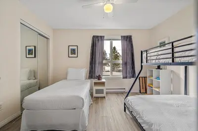 a bedroom with two bunk beds and a window at Polar Peaks Hot Tub Pool Gas Fireplace in Radium Hot Springs