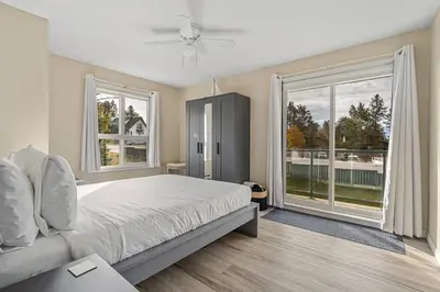 a bedroom with a bed and a large window at Polar Peaks Hot Tub Pool Gas Fireplace in Radium Hot Springs