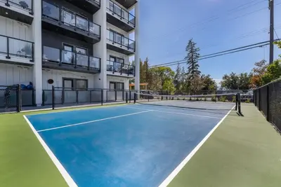 a tennis court in front of a building at Top Floor Lakeshore Views Near Skiing in Vernon