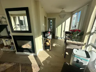a living room with a fireplace and a mirror at Penthouses of Beach Ave in Vancouver