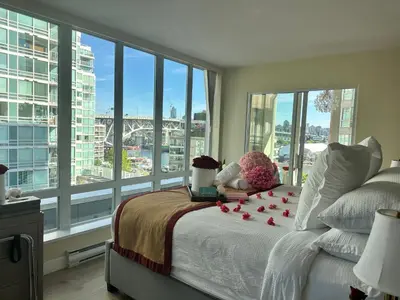 a bedroom with a bed with red roses on it at Penthouses of Beach Ave in Vancouver